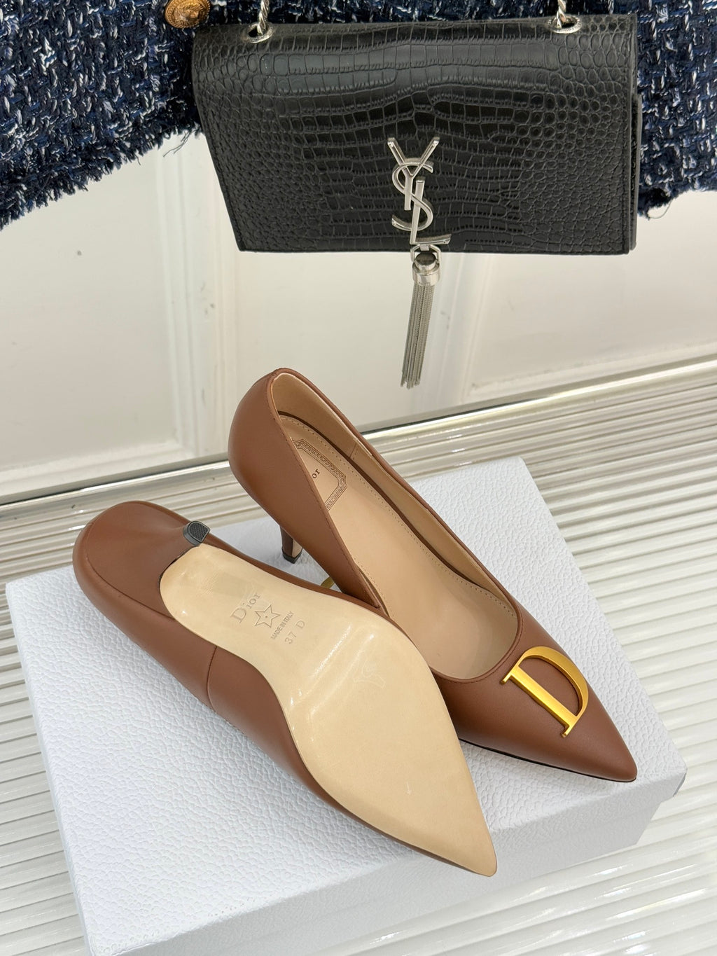 Dior ladies' tan pointed-toe pumps with slim heel and gold D emblem on vamp