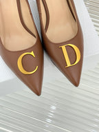 Dior ladies' tan pumps close-up with gold C and D motifs on pointed toes