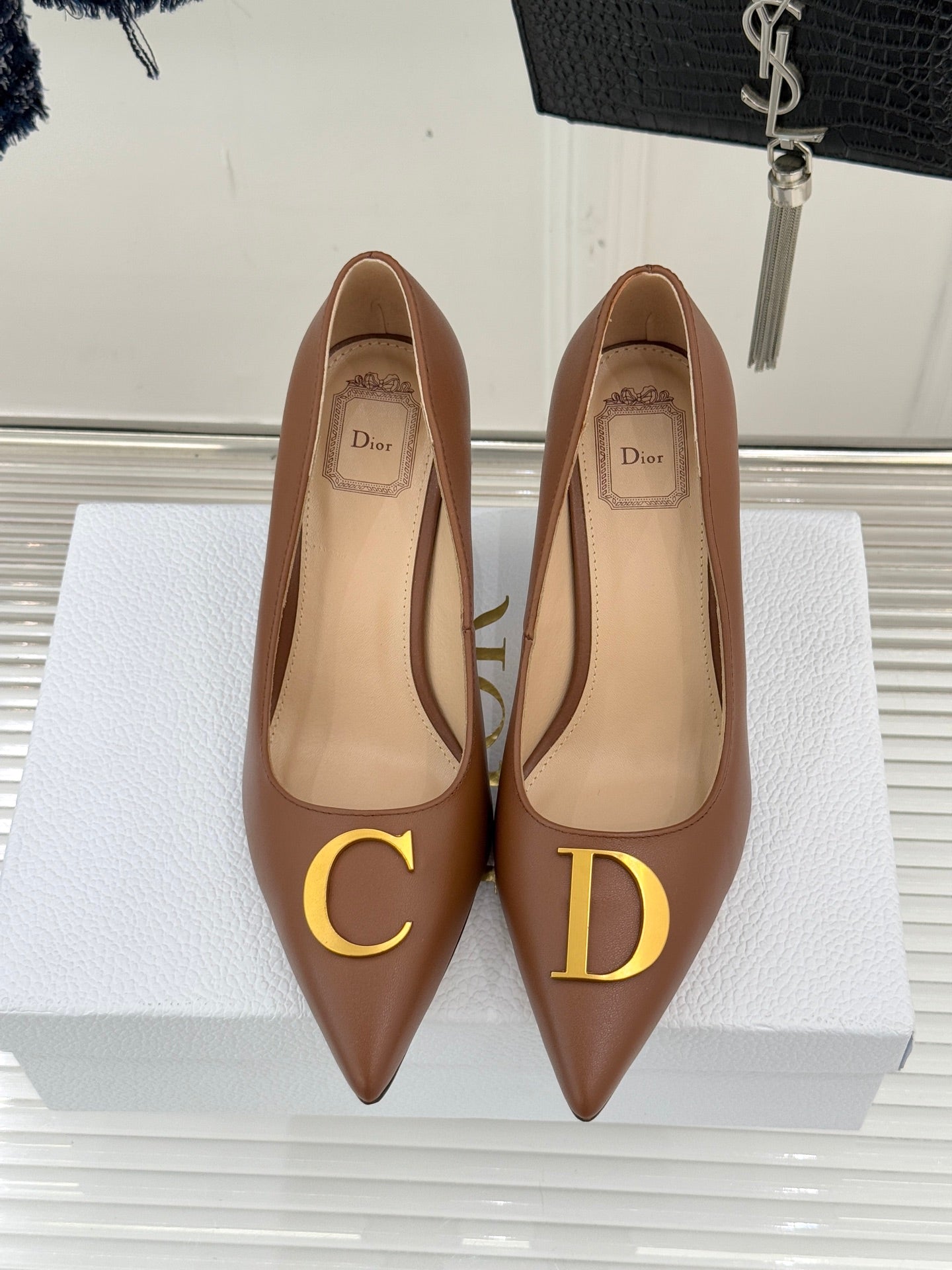 Dior ladies' tan pointed-toe pumps with gold C and D motifs on the front