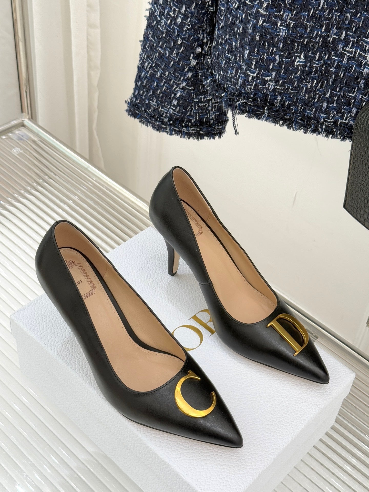 Pair of black pointed-toe high-heel pumps with gold C and D accents
