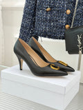 Black pointed-toe high-heel pumps with gold C detail on front