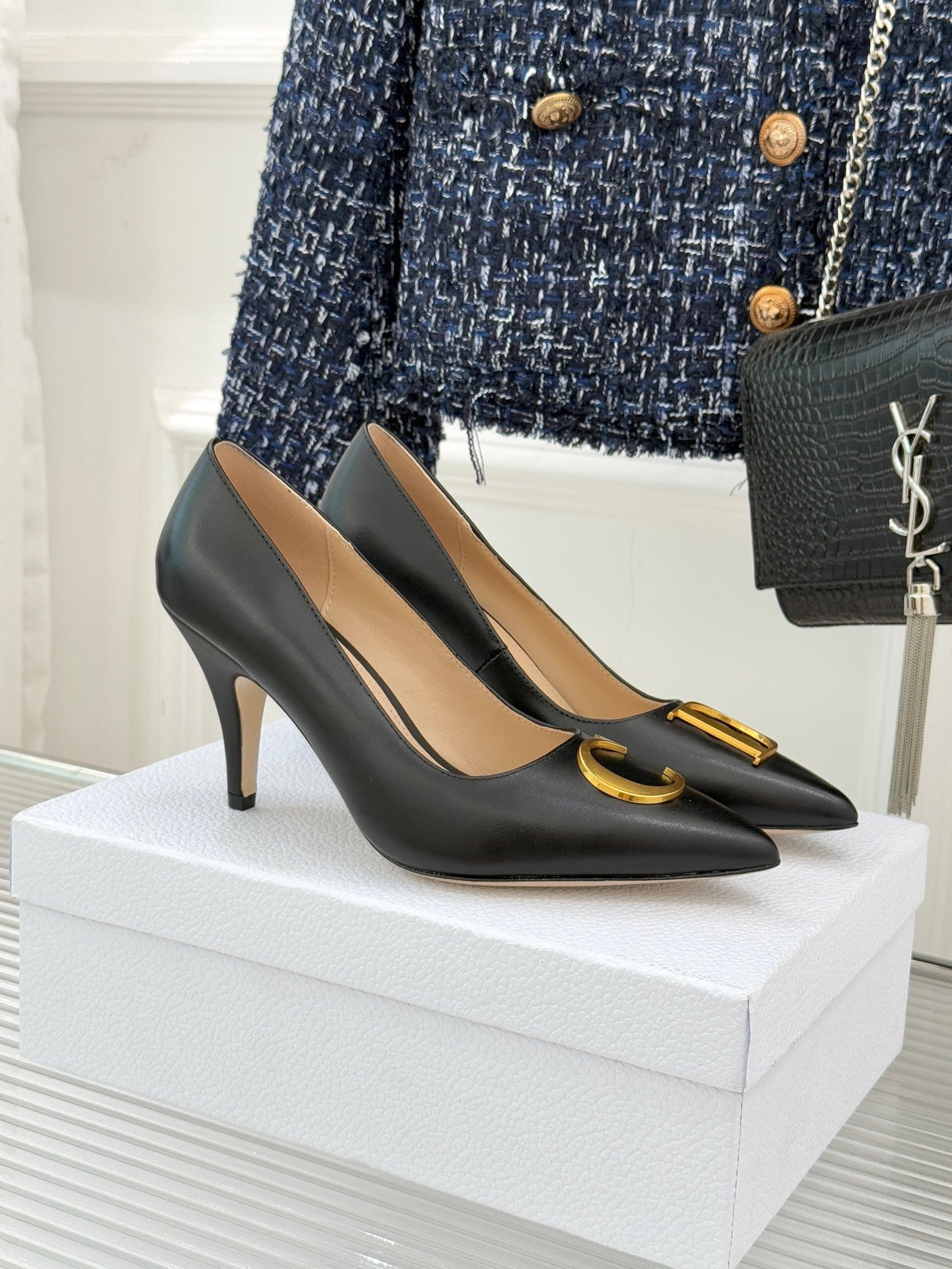 Black pointed-toe high-heel pumps with gold C detail on front