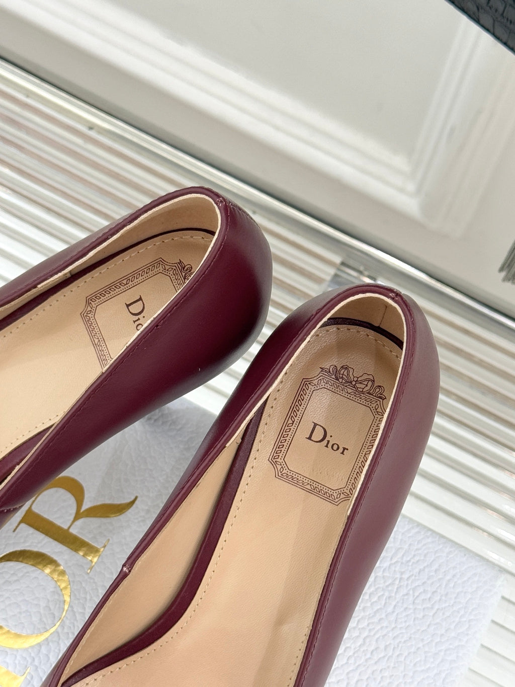 Maroon pointed-toe pumps with beige insole detail, toe and heel close-up