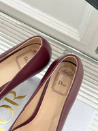 Maroon pointed-toe pumps with beige insole detail, toe and heel close-up