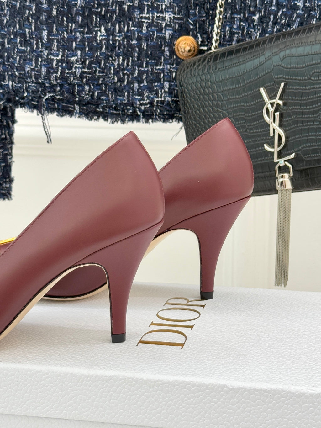 Maroon stiletto pumps, close-up of curved heel and pointed toe