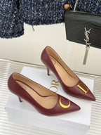 Maroon pointed-toe stiletto pumps with gold D and C emblem on vamps