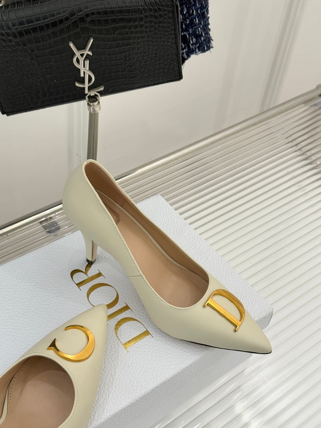Cream pointed-toe high-heel pumps with gold D ornament