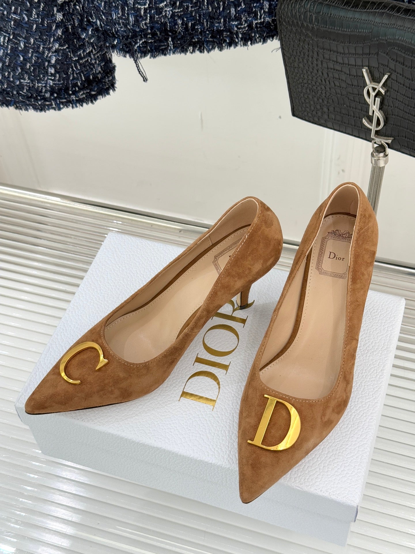 Tan suede pointed-toe stiletto pumps with gold C emblem on the vamp