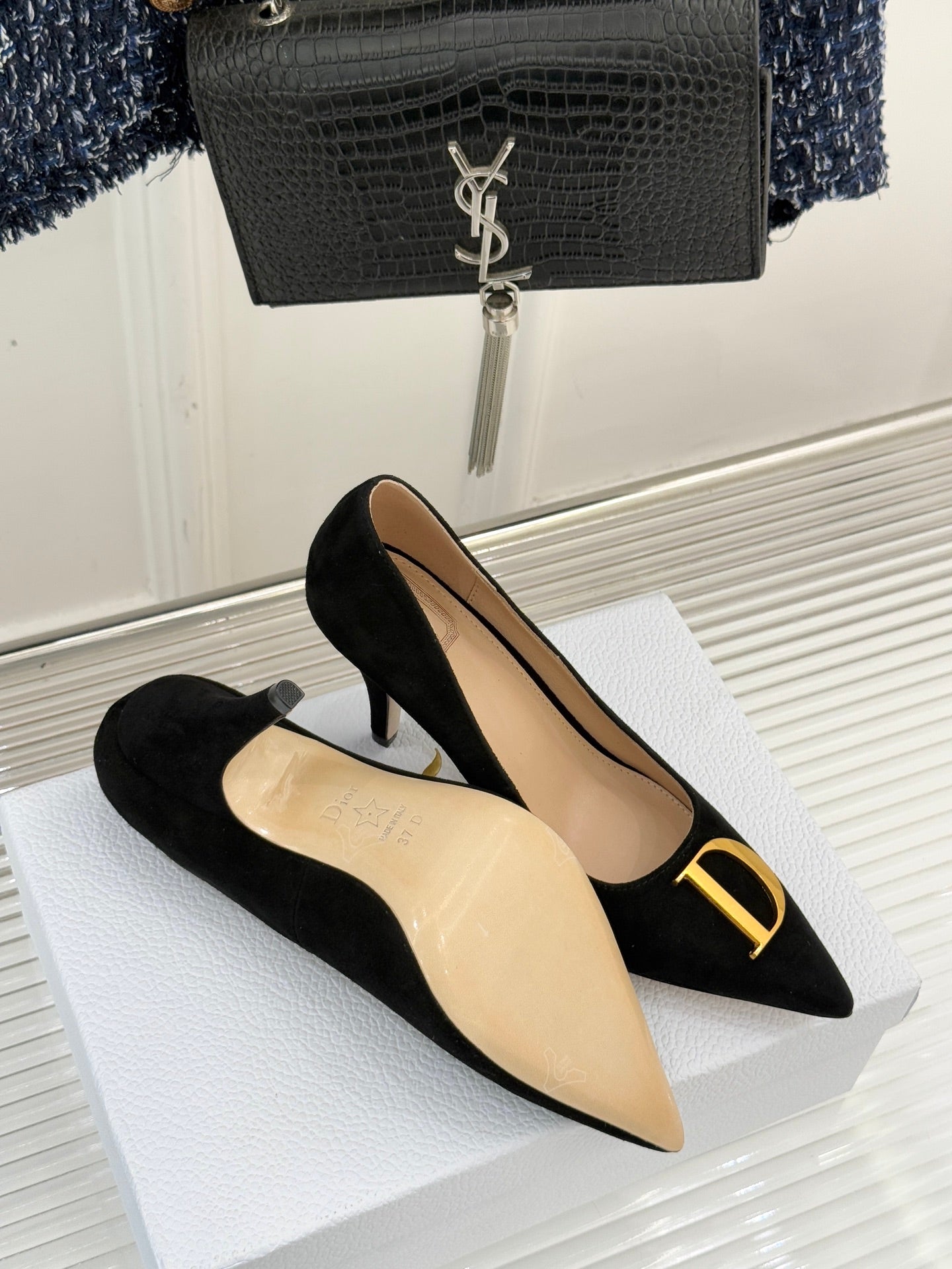 Black suede pointed stiletto pumps with gold logo at toe