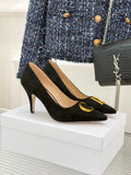 Black suede stiletto pumps with gold logo trim