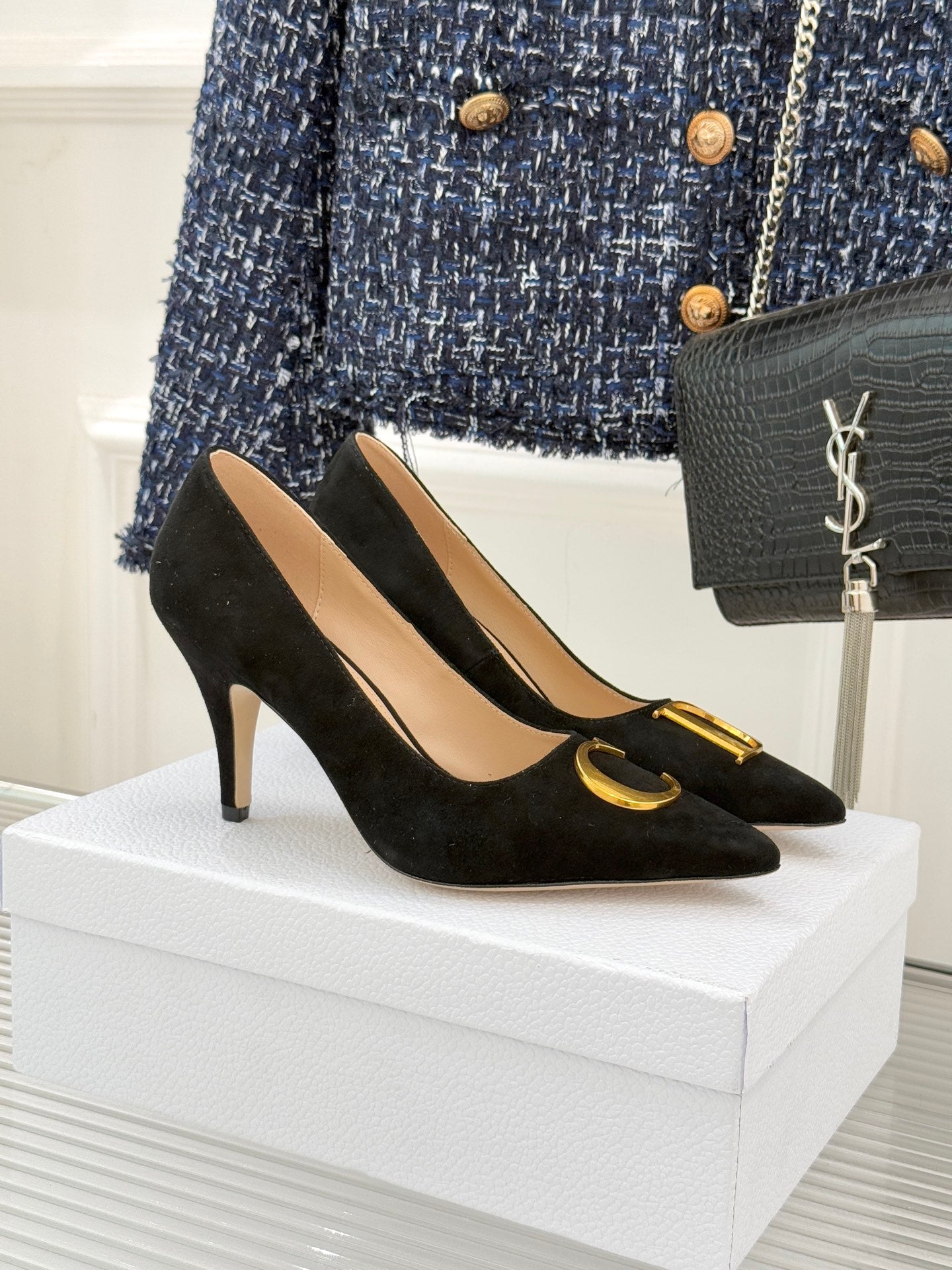 Black suede stiletto pumps with gold logo trim