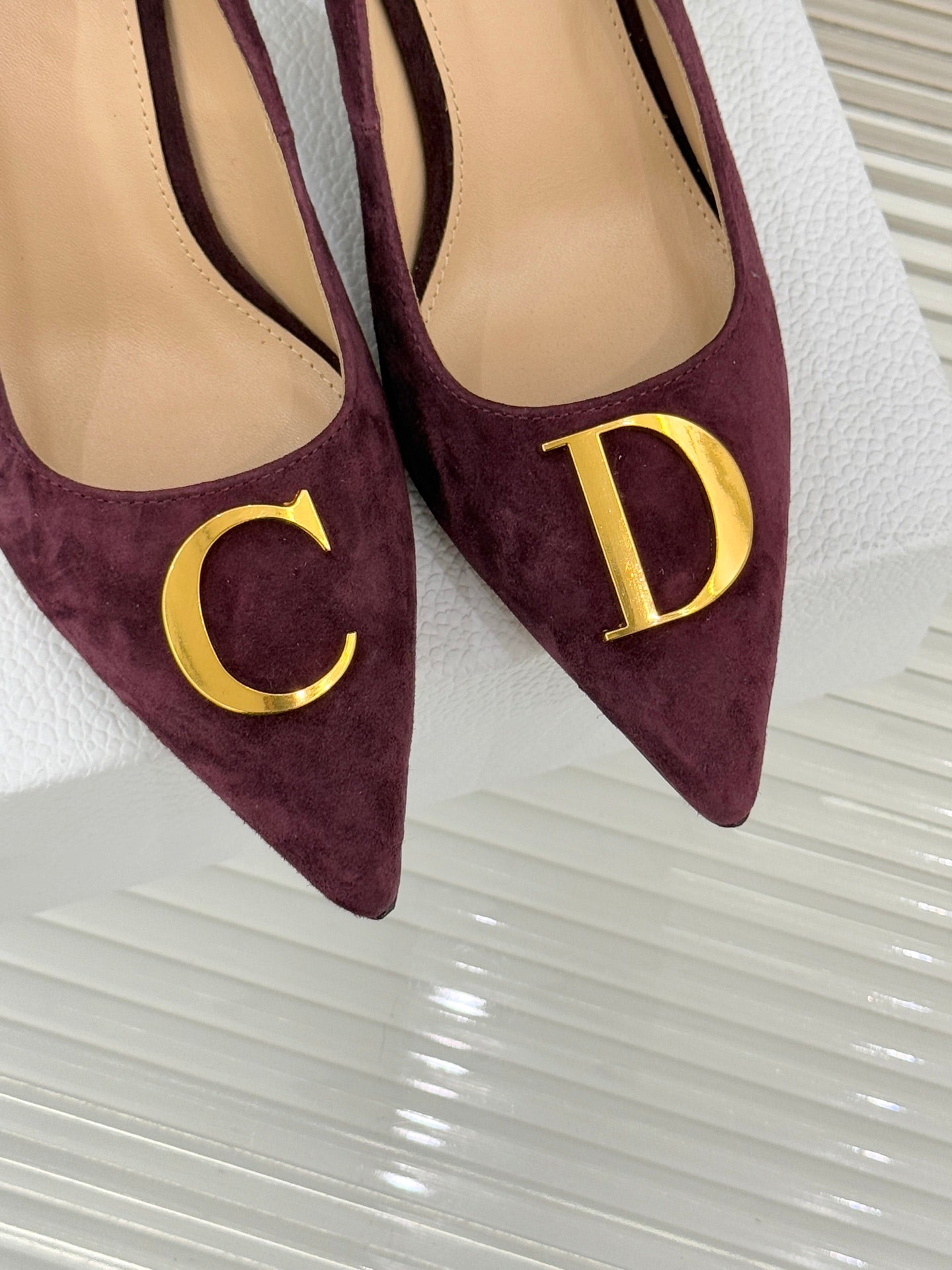 Dior ladies suede pumps close-up, pointed toe, burgundy with gold C and D emblems