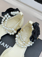 Chanel ladies' cream flats with black bows and pearl beaded strap and chain detail