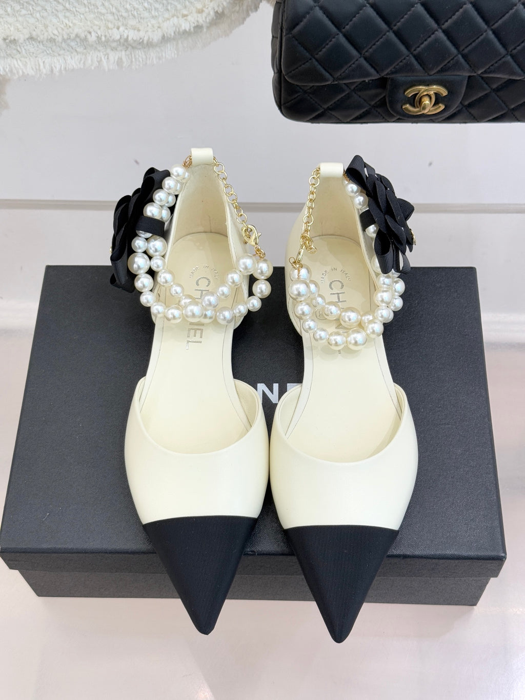 Chanel ladies' cream pointed flats with black heel tips and pearl bow strap detail