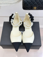 Chanel ladies' cream pointed flats with black heel tips and pearl bow strap detail