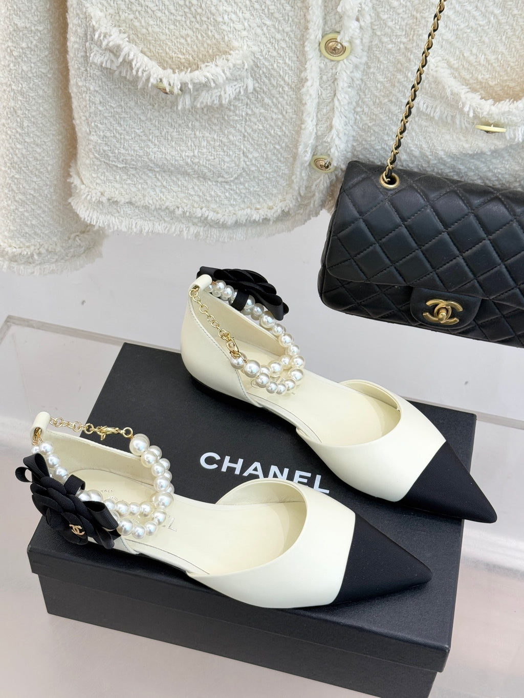 Chanel ladies' cream slingback flats with black toe band and pearl bow ornament