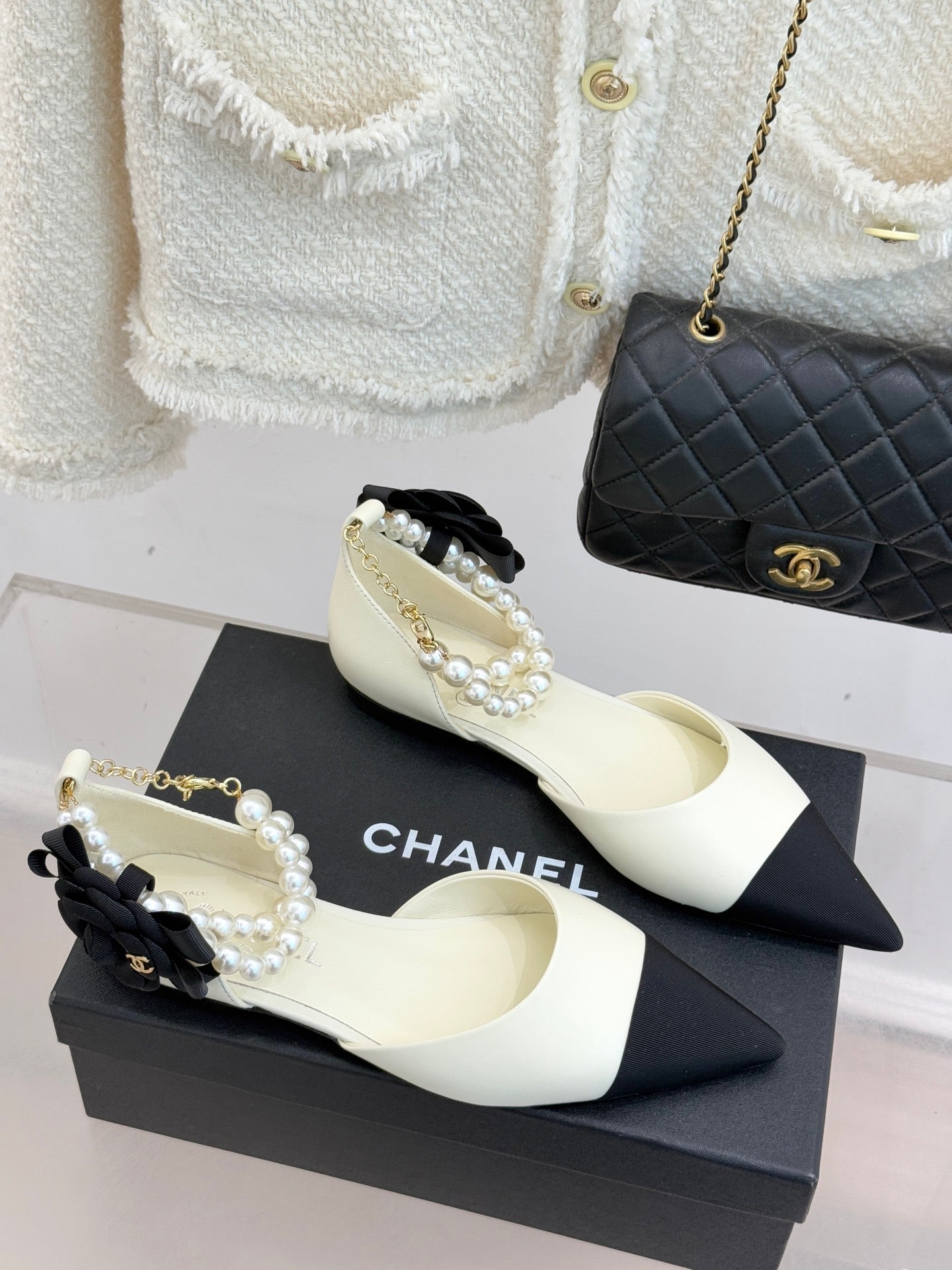 Chanel ladies' cream slingback flats with black toe band and pearl bow ornament