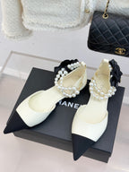 Chanel ladies' white flats with black pointed toe, pearl bead strap and bow detail