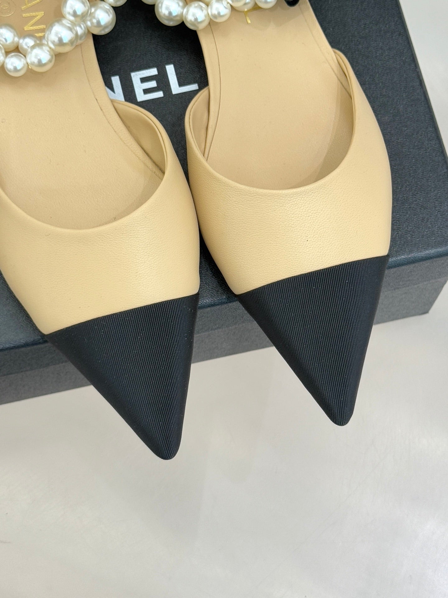 Two Chanel flats, beige pointed-toe uppers with dark pointed heel tips