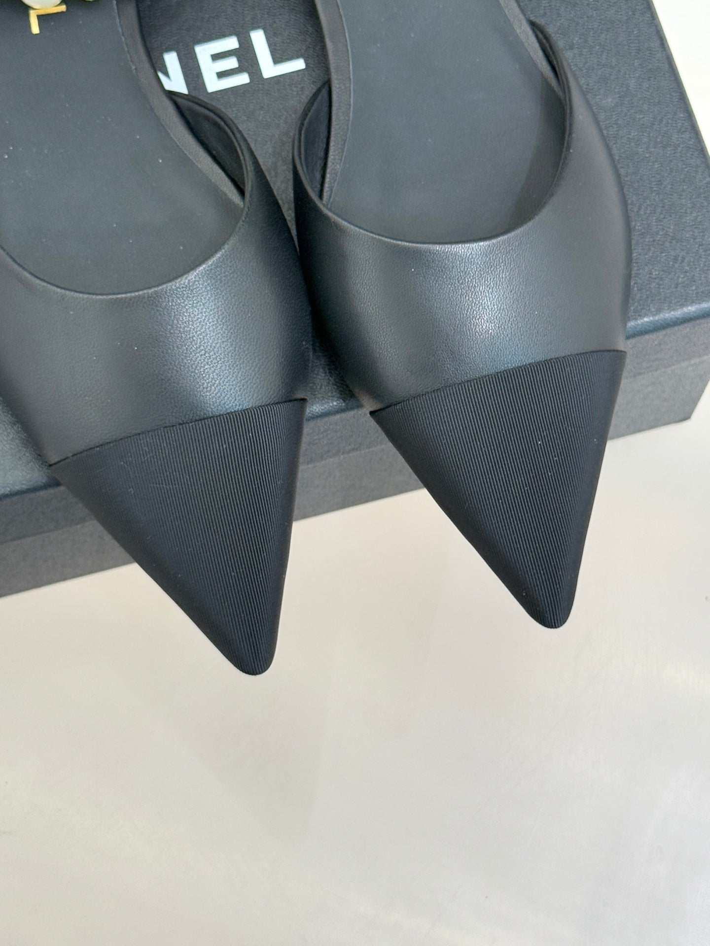 Chanel ladies black mules with pointed toe and slim heel, side view