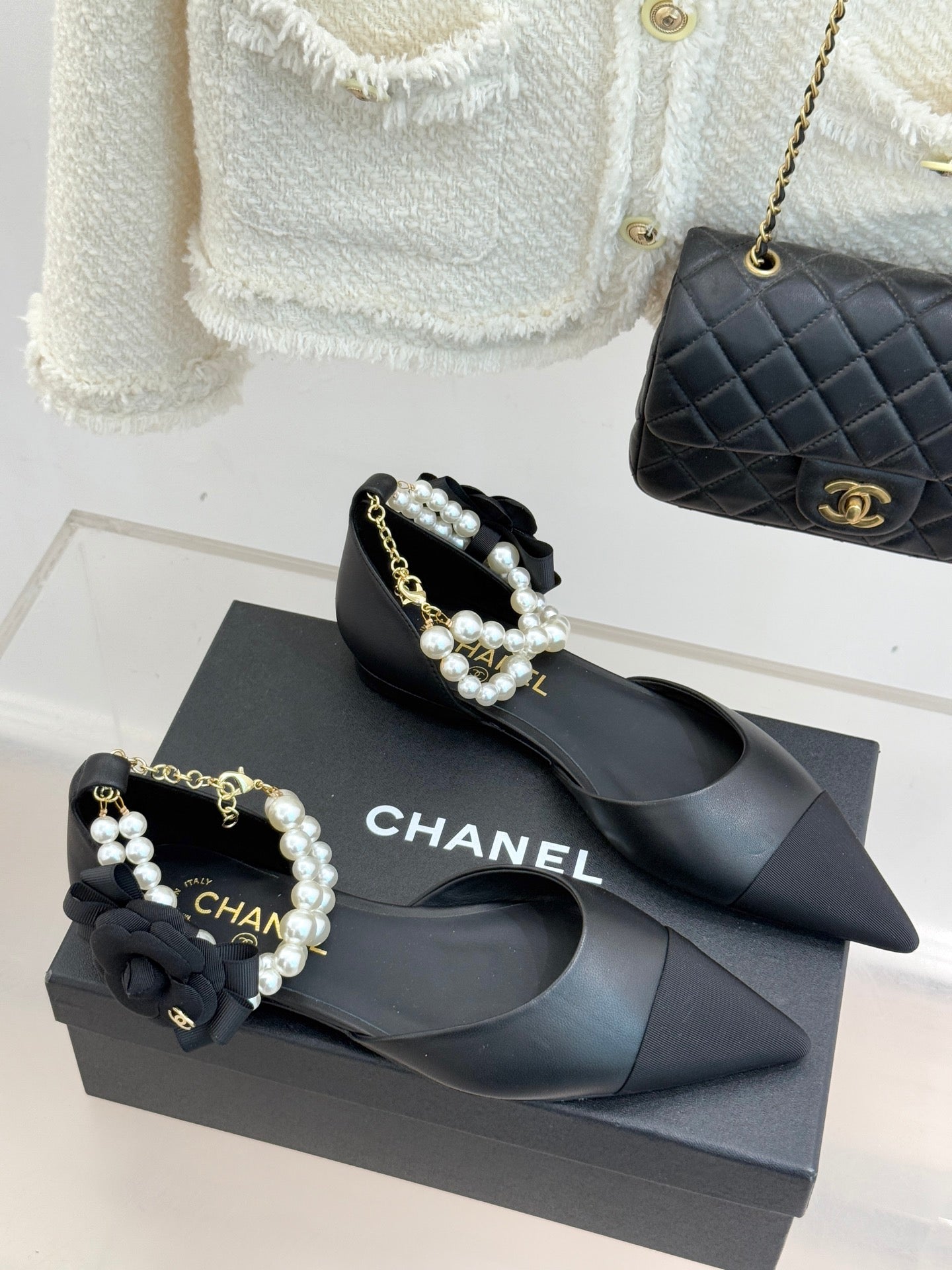 Chanel ladies black mules with pearl beaded strap and gold chain, on dark box