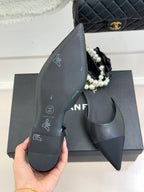 Chanel ladies black mules side view with pointed toe and faux pearl strap