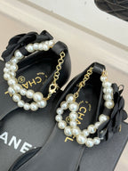 Chanel ladies black mules with faux pearl straps, gold chain, and CHANEL detail