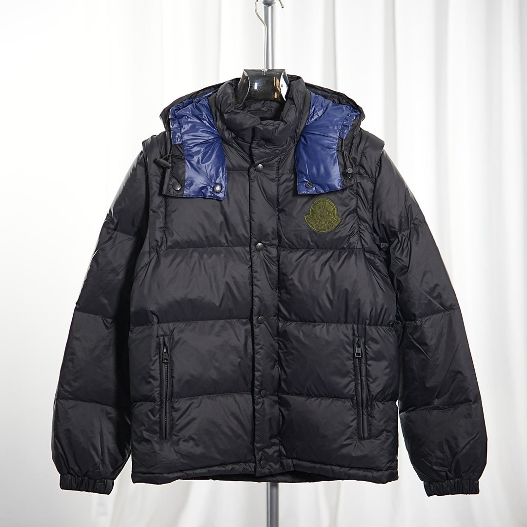 Moncler long puffer jacket front view, dark body with blue shoulder panels, hood, logo badge