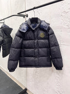 Moncler long puffer jacket on hanger, dark outer with quilted body, hood, logo badge