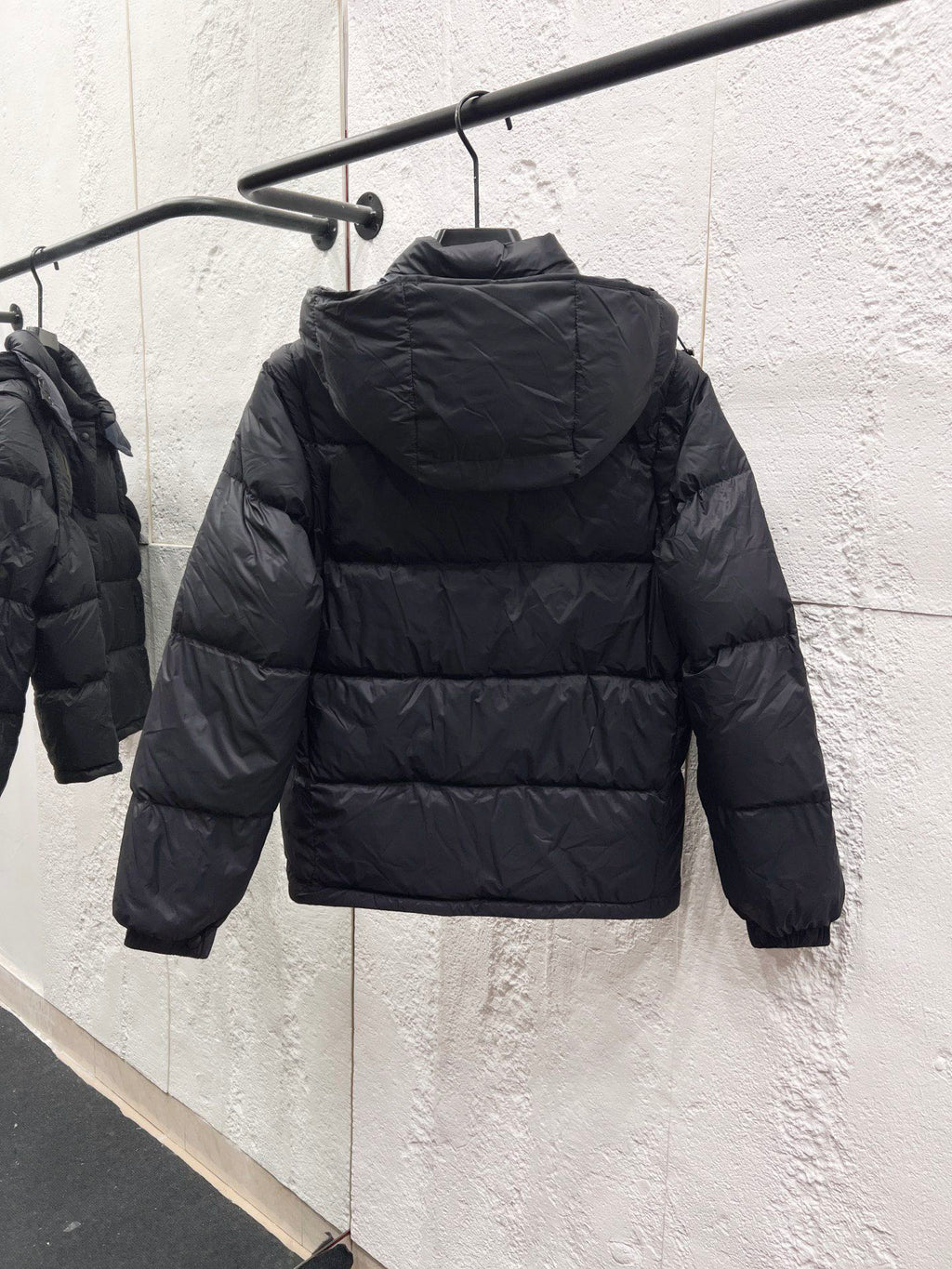 Moncler long puffer jacket back view on hanger, dark quilted puffer with hood