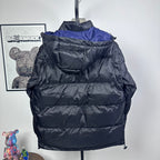 Moncler long puffer jacket back view, hooded, dark with blue shoulder panel, quilted zip