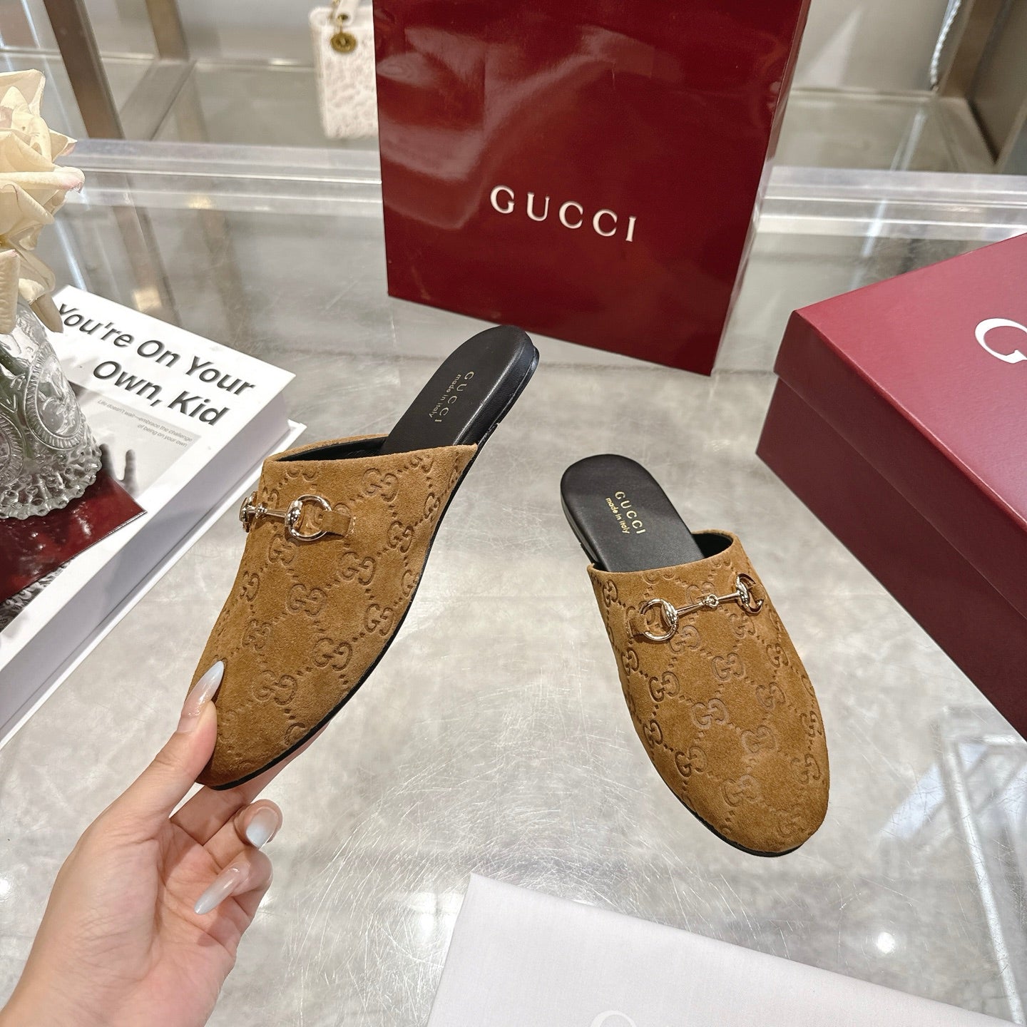Gucci unisex GG-pattern mule on hand, gold horsebit, dark lining, side view