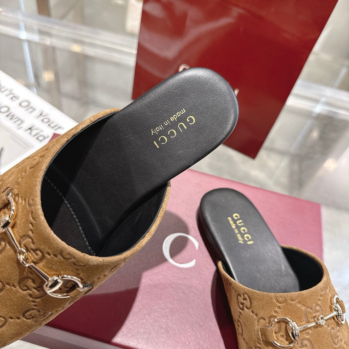 Gucci unisex mules with gold horsebit; tan upper and black insole, close-up