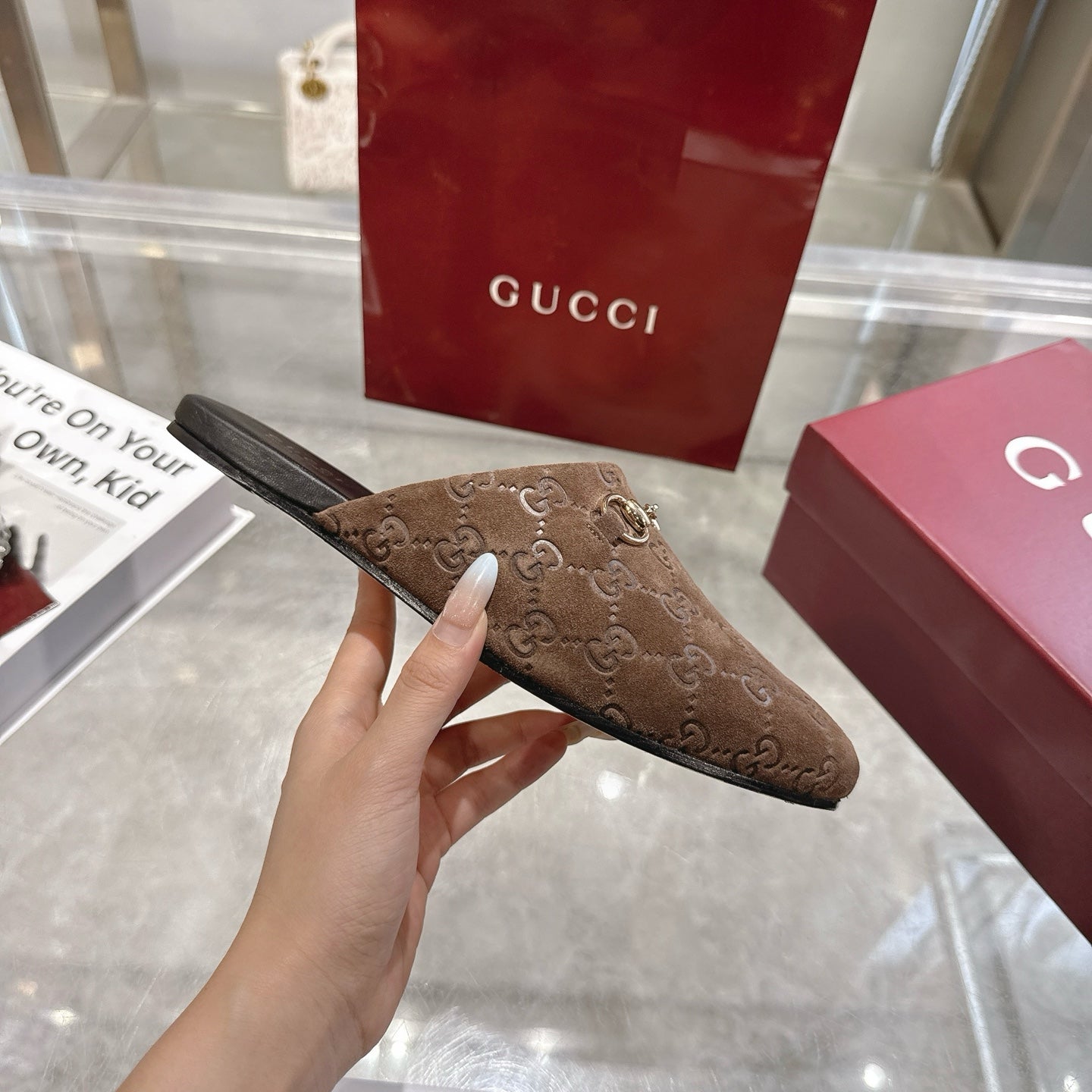 Gucci unisex mule with GG monogram upper and gold-tone horsebit, side profile, brown