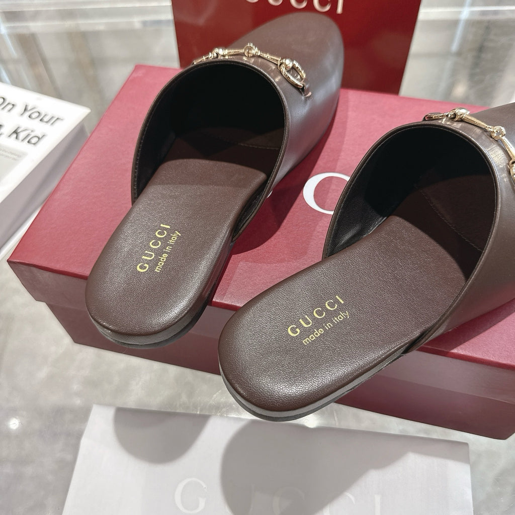 Gucci unisex leather mule loafers showing interior lining and gold horsebit hardware.