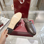 Gucci unisex leather loafer mule with gold horsebit and visible light outsole from below.