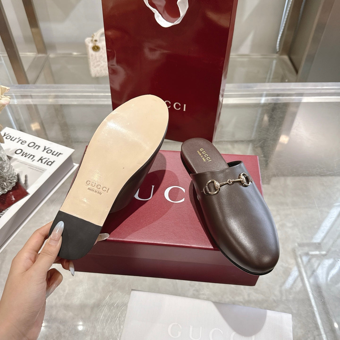 Gucci unisex leather loafer mule with gold horsebit and visible light outsole from below.
