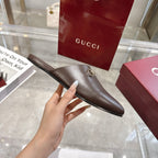 Gucci unisex leather mule loafer with gold-toned horsebit, shown from side profile.