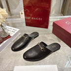 Gucci black leather mule shoes with gold-tone horsebit detail, slip-on design