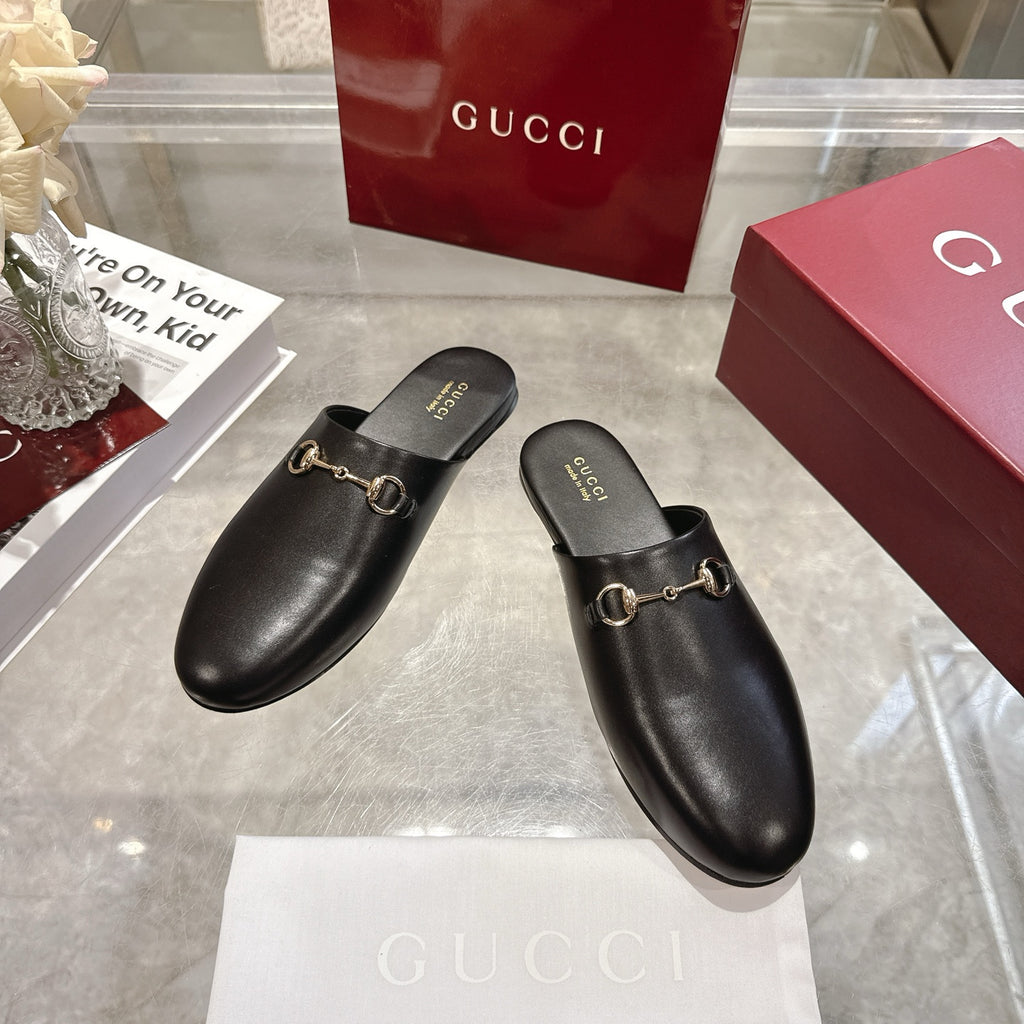 Gucci black leather horsebit mules, angled pair view, slip-on with gold-tone hardware