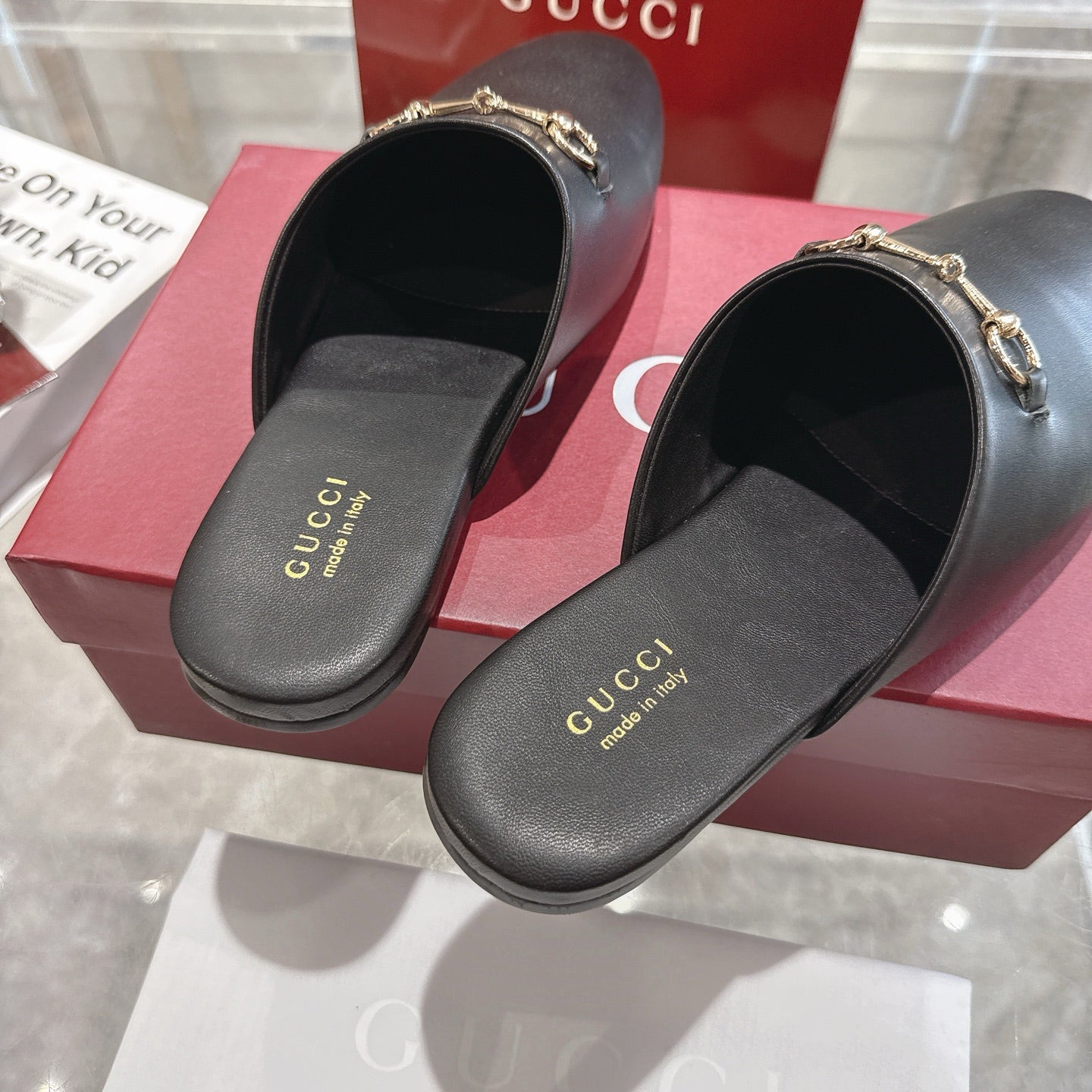 Gucci black leather horsebit slides with gold-tone chain, cushioned footbed