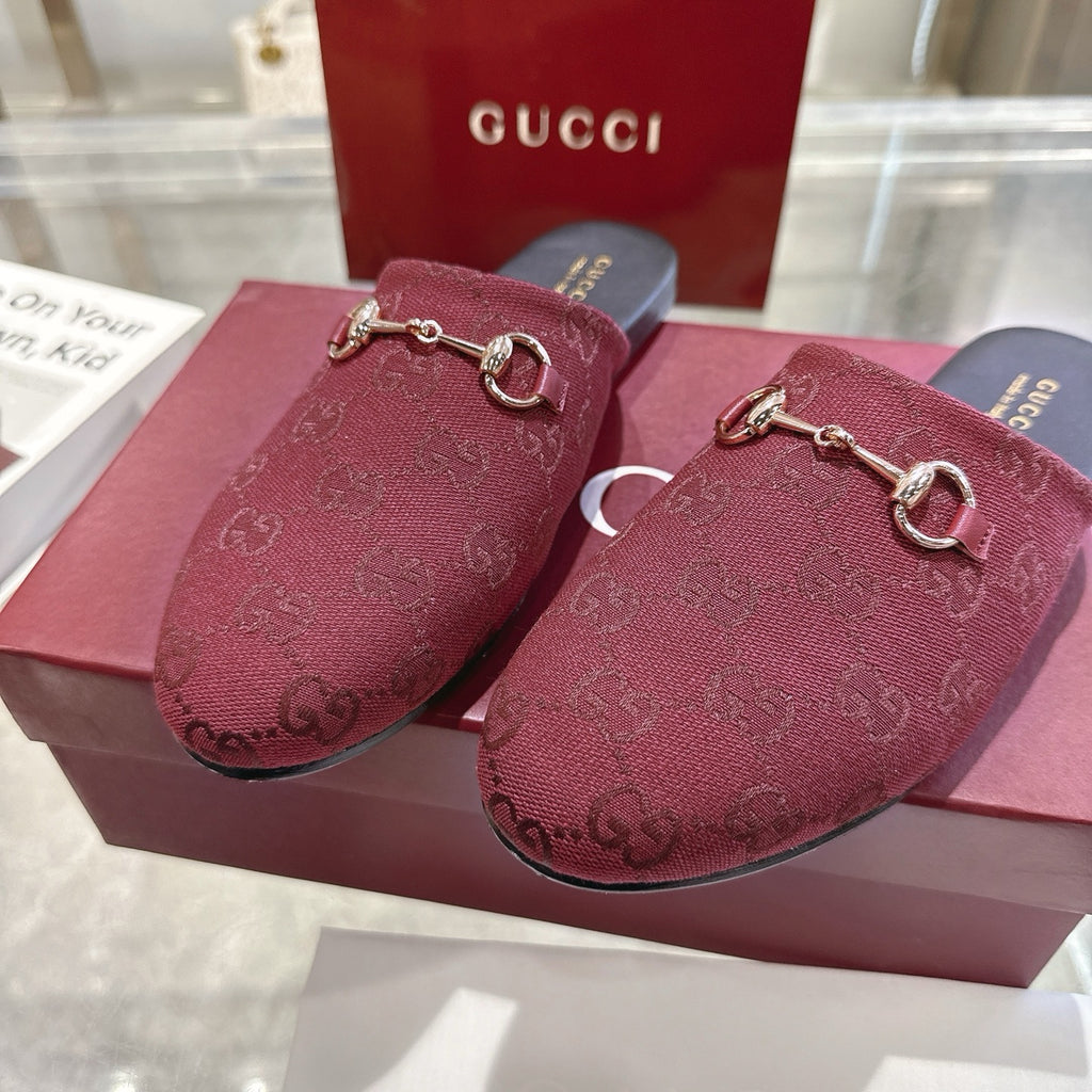 Close-up of Gucci unisex burgundy GG horsebit slides with gold-tone bit hardware