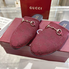 Close-up of Gucci unisex burgundy GG horsebit slides with gold-tone bit hardware