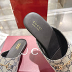 Gucci unisex GG monogram slide shoe close-up with gold-toned horsebit, black insole