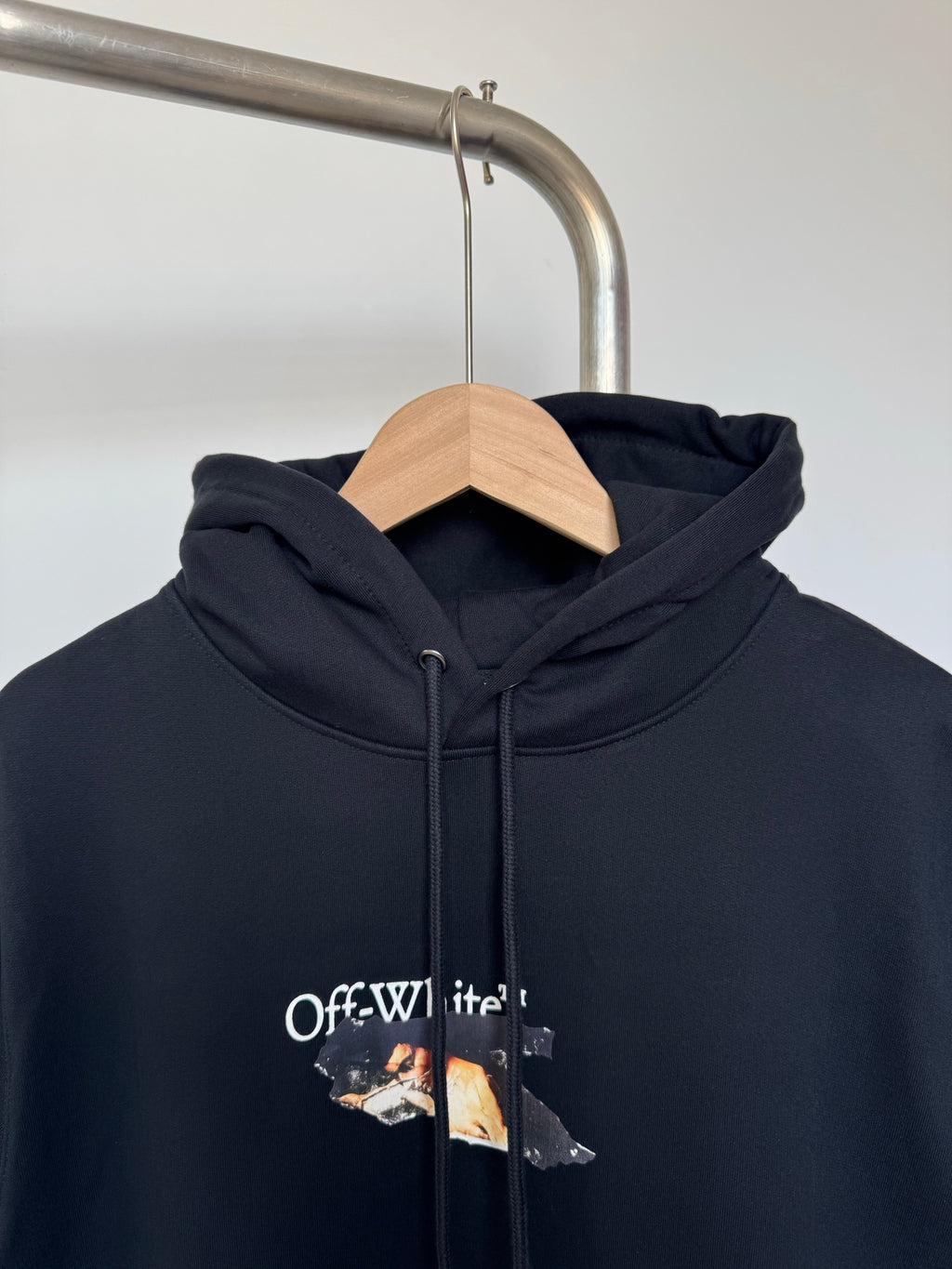 Off-White hoodie, black, close view of hood with drawstrings and chest graphic