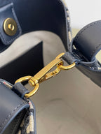 Gold clasp hardware on navy leather handle strap of Dior monogram bag