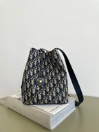 Small drawstring bucket bag in navy and beige Dior monogram print