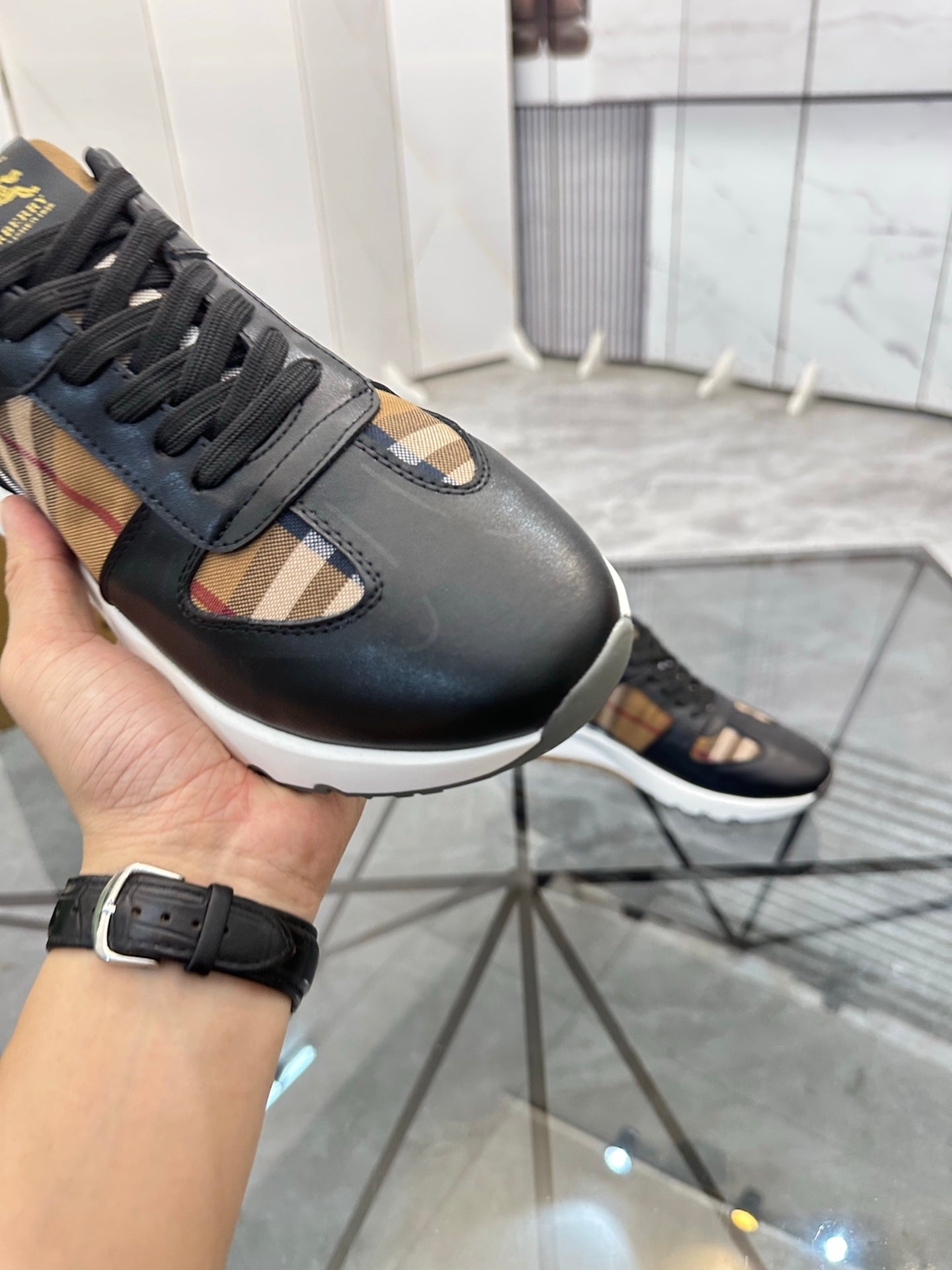 Black sneaker close-up on toe and side, lace-up with plaid inset panel