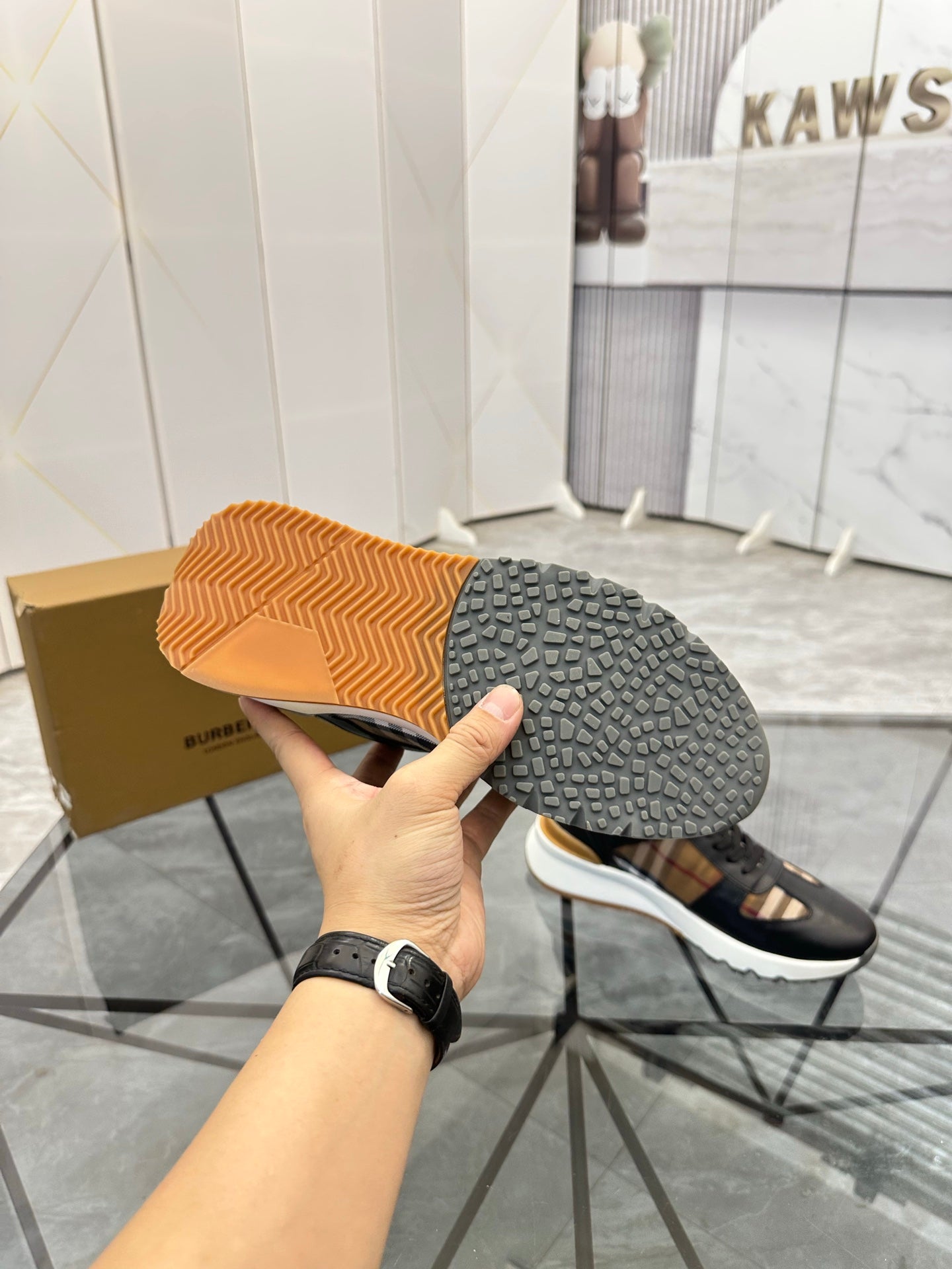 Black sneaker outsole view with textured tread and contrasting sole edge