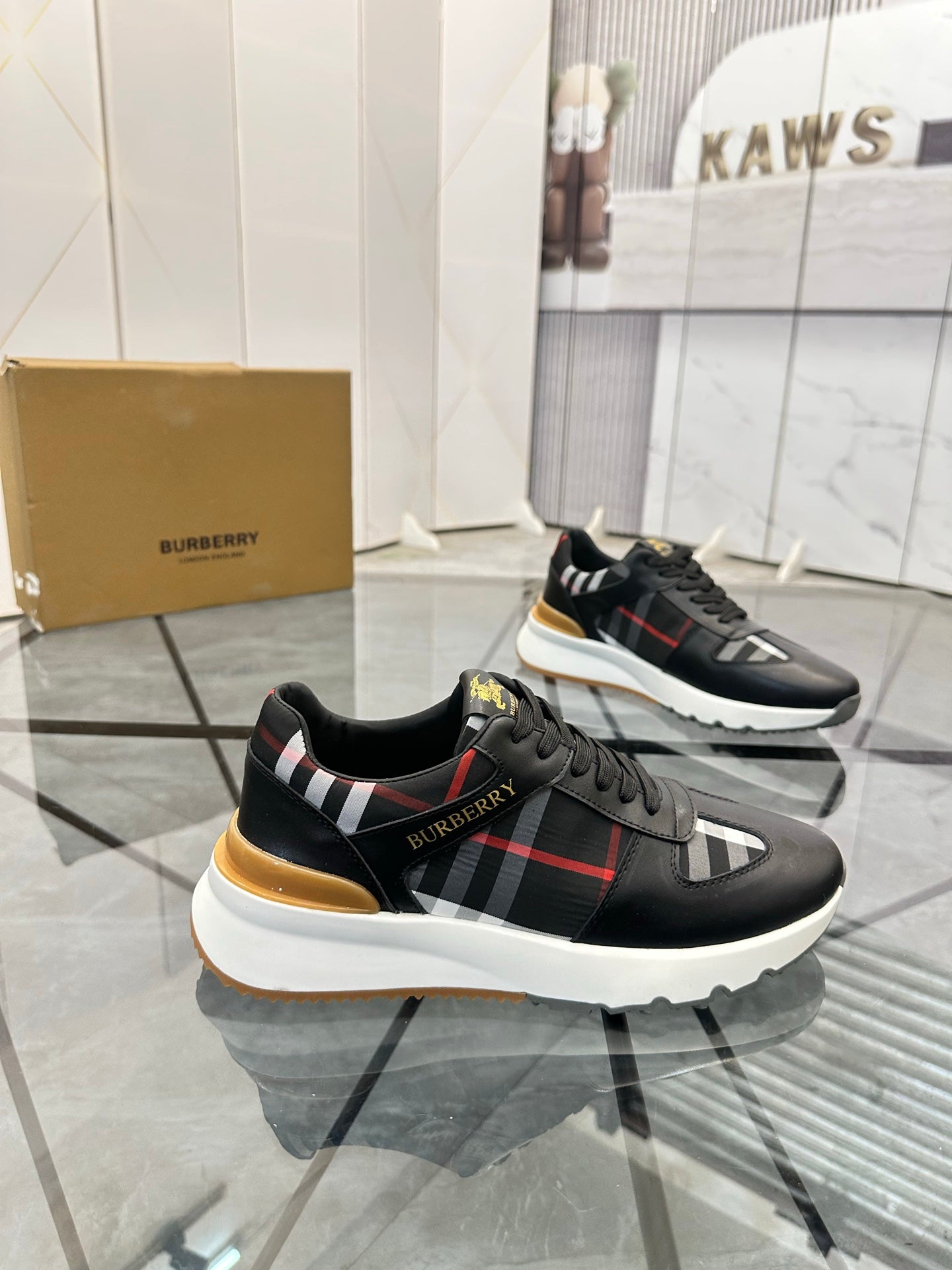 Black low-top sneakers with plaid side stripe and white midsole